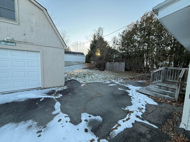 yard layered in snow featuring a garage