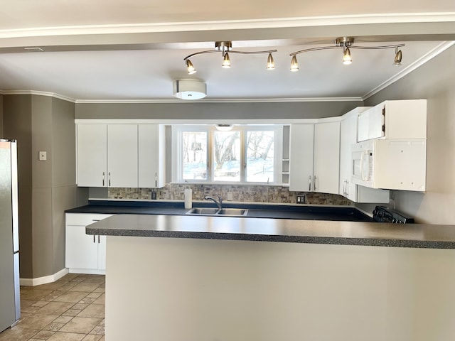 kitchen featuring sink, crown molding, white refrigerator, white cabinets, and decorative backsplash