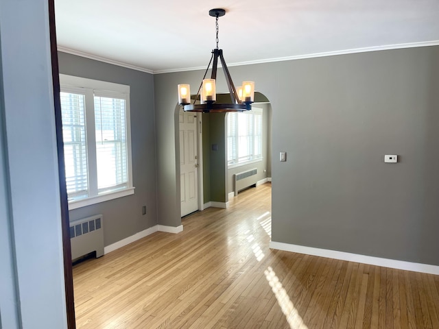 unfurnished dining area with crown molding, radiator heating unit, an inviting chandelier, and light hardwood / wood-style flooring