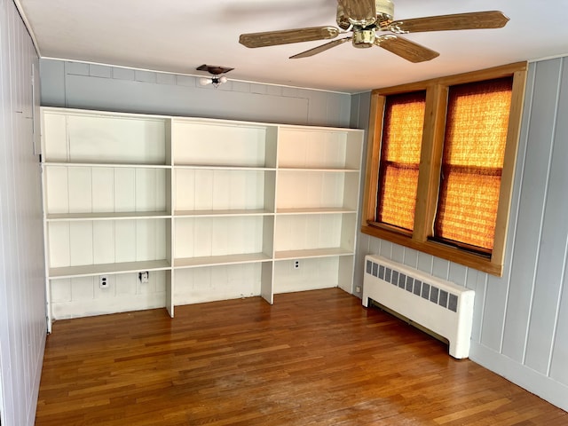 interior space with ceiling fan, radiator heating unit, and dark hardwood / wood-style flooring