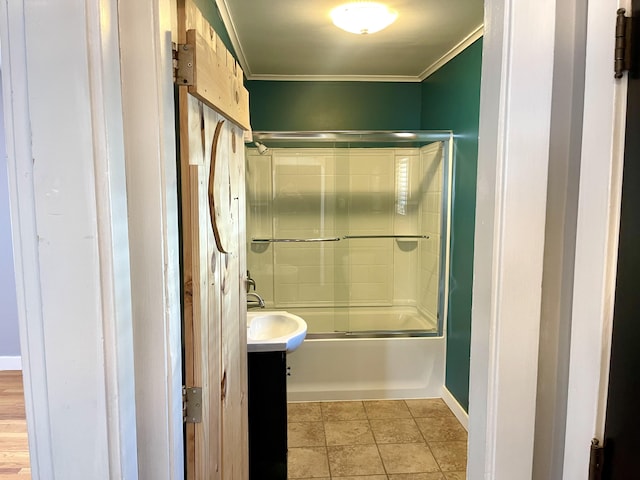 bathroom with tile patterned flooring, ornamental molding, vanity, and shower / bath combination with glass door