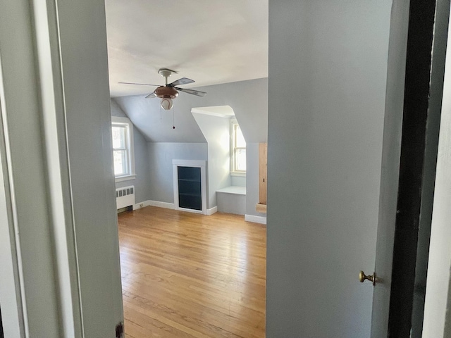 bonus room featuring ceiling fan, radiator, vaulted ceiling, and light hardwood / wood-style flooring