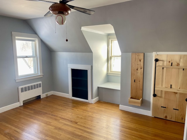 bonus room featuring lofted ceiling, radiator, ceiling fan, and light hardwood / wood-style flooring