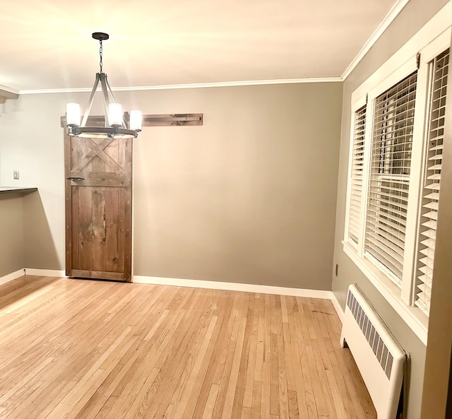 unfurnished dining area featuring ornamental molding, radiator heating unit, light hardwood / wood-style flooring, and a notable chandelier