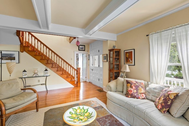 living room featuring beamed ceiling, crown molding, and light hardwood / wood-style floors