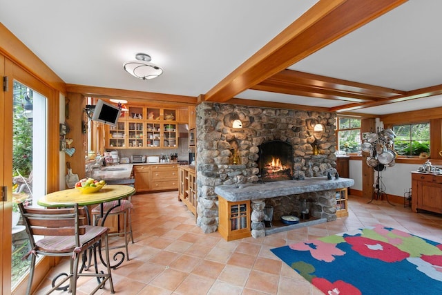 interior space with a fireplace, a wealth of natural light, sink, and light tile patterned flooring