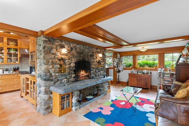 tiled living room featuring beamed ceiling and a stone fireplace