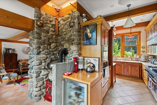 kitchen with wine cooler, decorative light fixtures, light tile patterned floors, a wood stove, and beamed ceiling