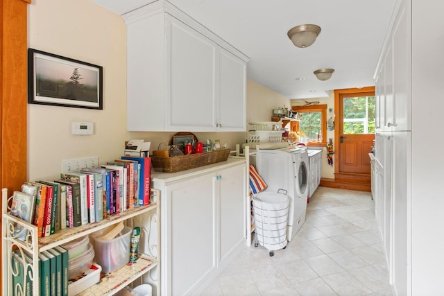 laundry room featuring light tile patterned floors, washing machine and dryer, and cabinets