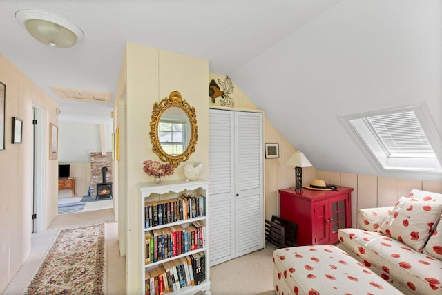 living area featuring lofted ceiling, light carpet, and wood walls