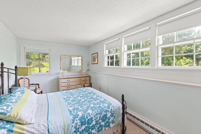 bedroom featuring a baseboard heating unit, carpet floors, and a textured ceiling