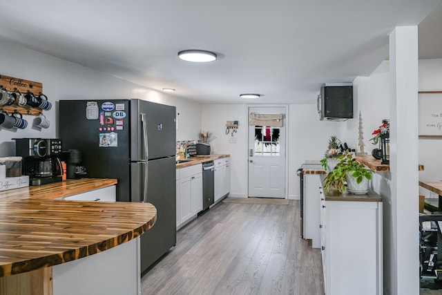 kitchen featuring appliances with stainless steel finishes, wooden counters, light hardwood / wood-style flooring, and white cabinets