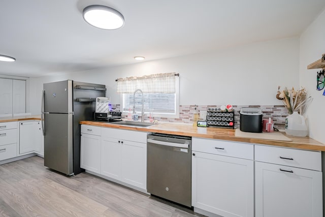 kitchen with white cabinetry, wood counters, appliances with stainless steel finishes, and sink