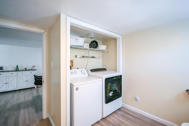 laundry room with wood-type flooring and washing machine and clothes dryer