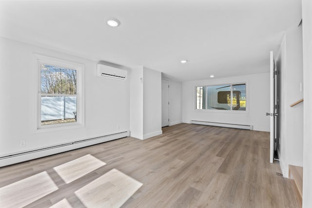 unfurnished living room featuring baseboard heating, a wall mounted air conditioner, a baseboard heating unit, light wood finished floors, and recessed lighting