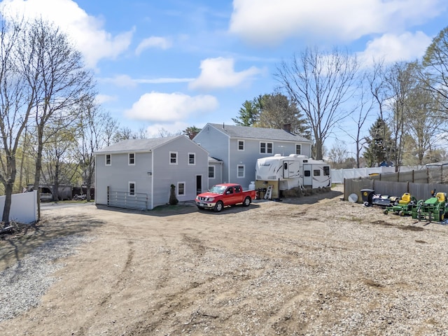 rear view of property with fence and a chimney