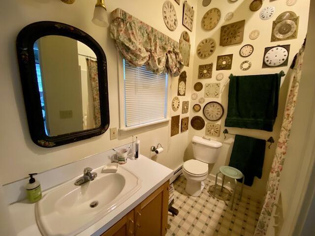 bathroom with a baseboard radiator, vanity, and toilet