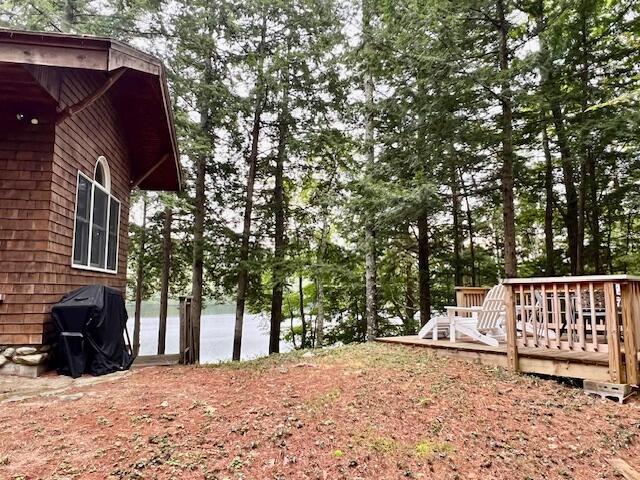 view of yard with a deck with water view