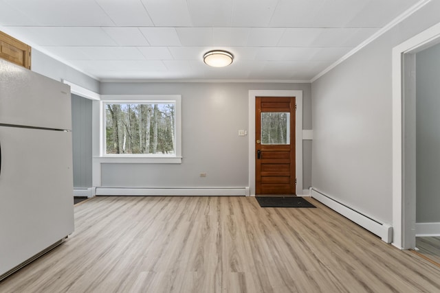 interior space with crown molding, a baseboard heating unit, and a wealth of natural light