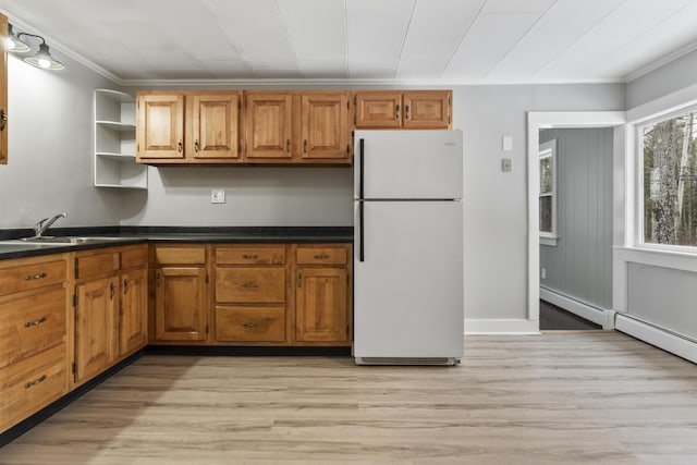 kitchen featuring sink, crown molding, light hardwood / wood-style flooring, and white fridge