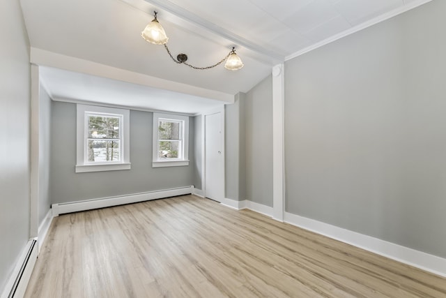 unfurnished room with light hardwood / wood-style flooring, ornamental molding, vaulted ceiling, and baseboard heating