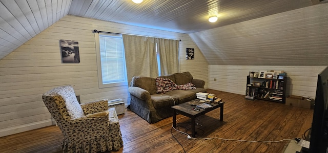 living room featuring lofted ceiling, hardwood / wood-style floors, and wooden walls