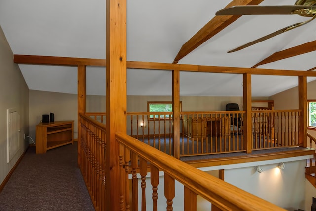 corridor with vaulted ceiling with beams and dark carpet