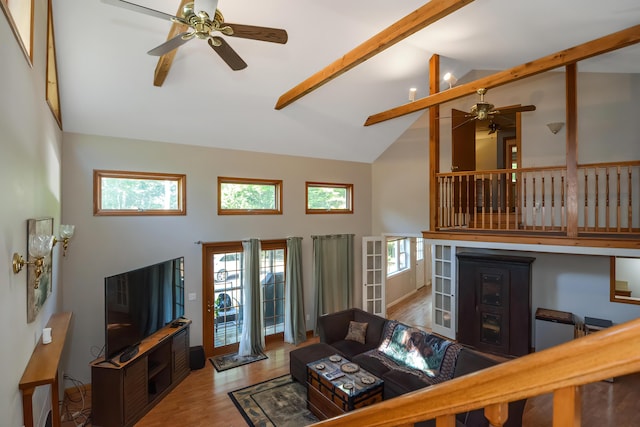 living room featuring beam ceiling, ceiling fan, high vaulted ceiling, and light wood-type flooring