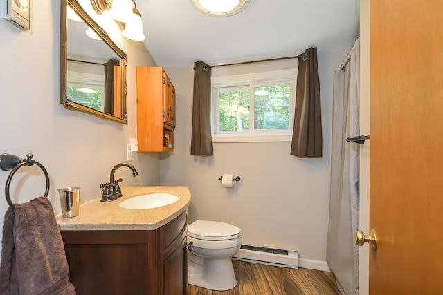 bathroom with vanity, hardwood / wood-style floors, toilet, and baseboard heating