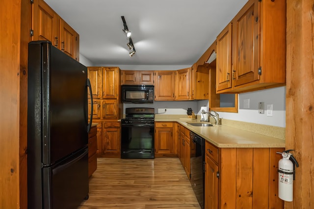 kitchen with light hardwood / wood-style floors, sink, and black appliances