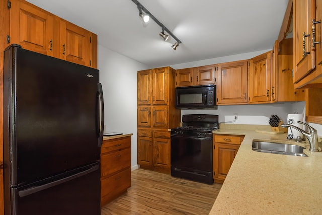 kitchen featuring track lighting, sink, light hardwood / wood-style flooring, and black appliances