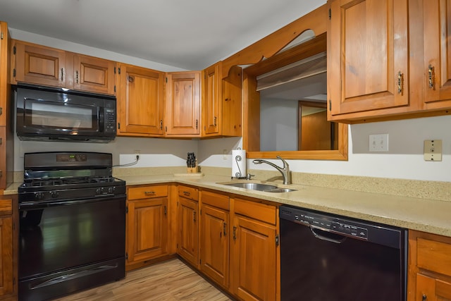 kitchen featuring sink, light hardwood / wood-style flooring, and black appliances