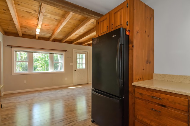 kitchen with light hardwood / wood-style flooring, wooden ceiling, beamed ceiling, and black fridge