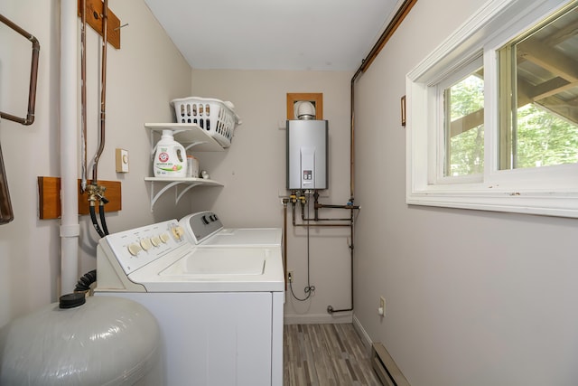 clothes washing area with hardwood / wood-style flooring, separate washer and dryer, and water heater