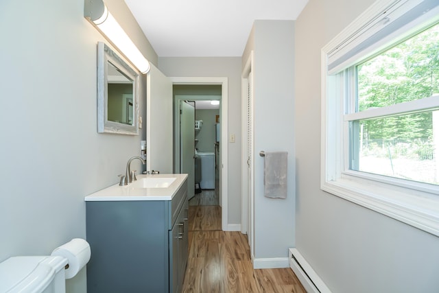 bathroom with vanity, a baseboard heating unit, hardwood / wood-style floors, and toilet