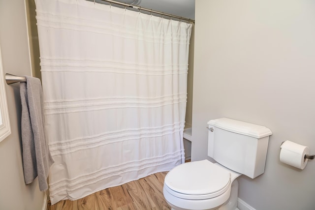 bathroom featuring hardwood / wood-style flooring, curtained shower, and toilet