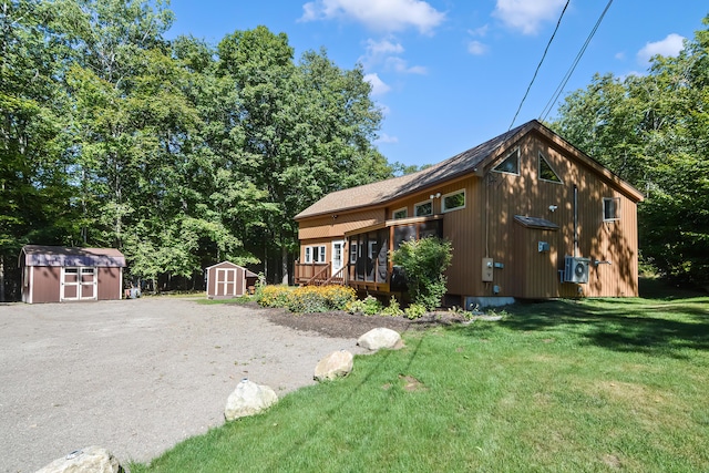 view of front of property with a deck, a shed, and a front yard