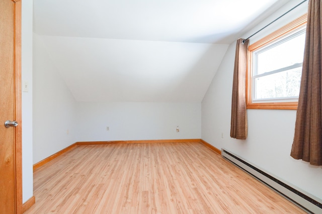 bonus room with lofted ceiling, a baseboard heating unit, and light hardwood / wood-style flooring