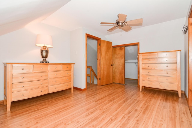 unfurnished bedroom featuring ceiling fan, lofted ceiling, light hardwood / wood-style floors, and a closet