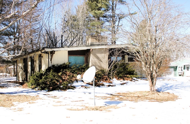 snow covered property featuring a chimney