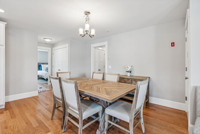 dining space featuring an inviting chandelier and light hardwood / wood-style flooring