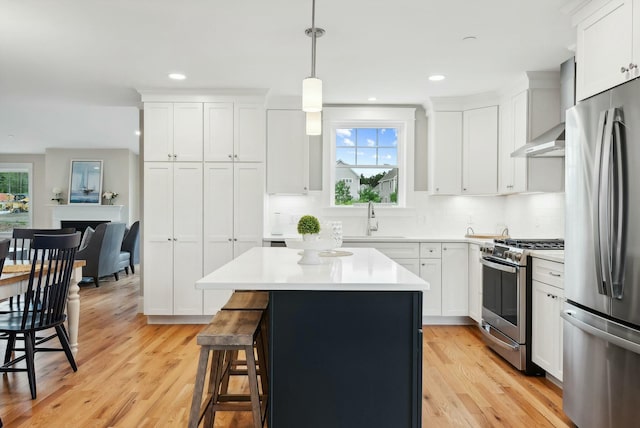 kitchen featuring stainless steel appliances, hanging light fixtures, and white cabinets