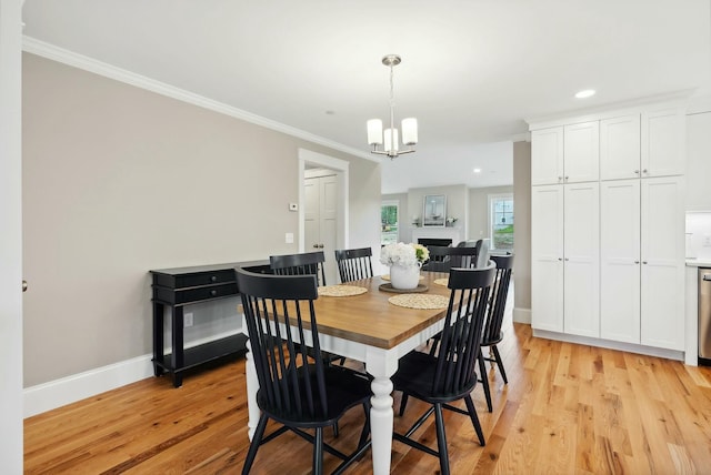 dining room featuring ornamental molding, an inviting chandelier, and light hardwood / wood-style floors