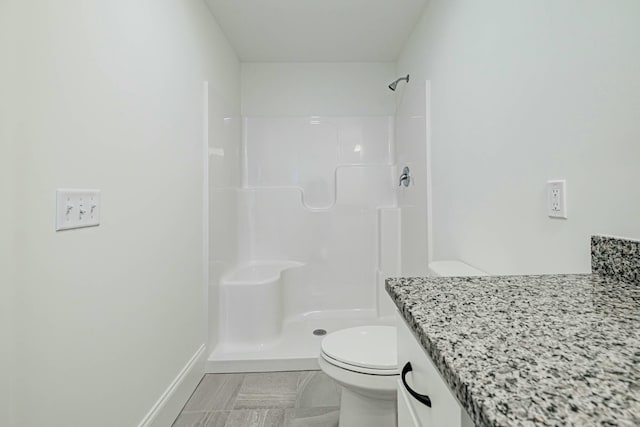 bathroom featuring vanity, toilet, and a shower