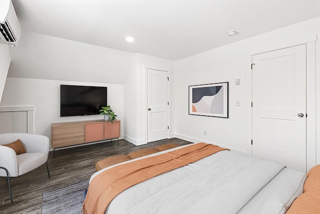 bedroom with dark wood-type flooring and a wall mounted AC