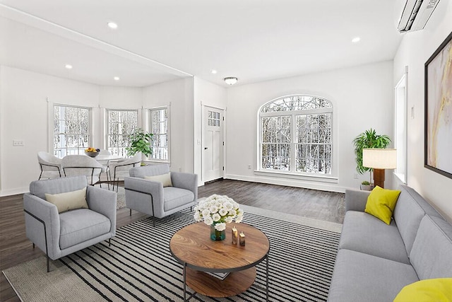 living room featuring dark wood-type flooring, a healthy amount of sunlight, and a wall unit AC