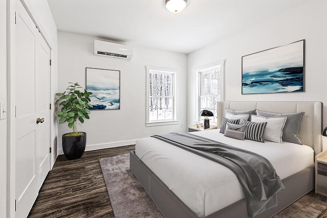 bedroom with dark hardwood / wood-style flooring and a wall mounted AC