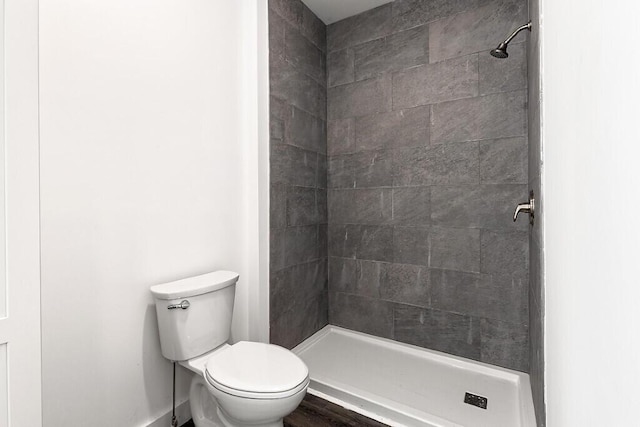 bathroom featuring toilet and tiled shower