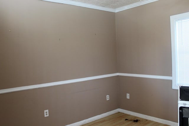 empty room with ornamental molding and light wood-type flooring