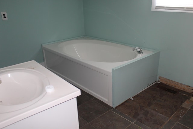 bathroom with a washtub and vanity